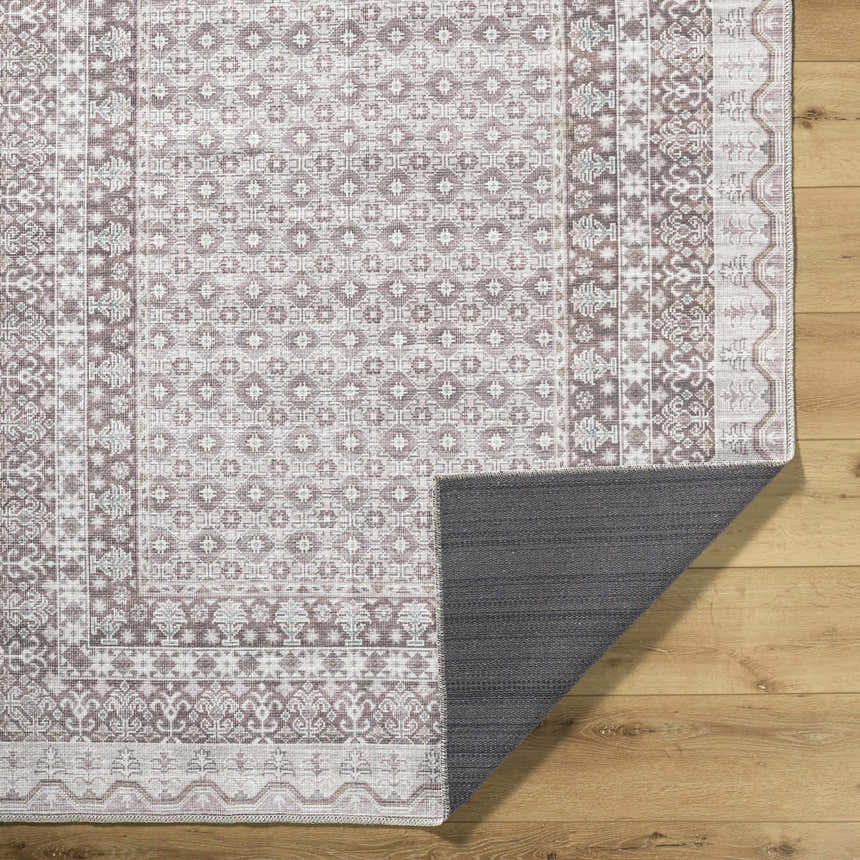 Close-up of Rainier Brown Washable Rug with traditional brown and gray pattern, showing the rug's backing. Fold