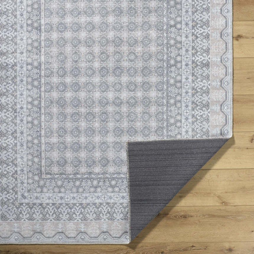 Close-up of Rainier Blue Washable Rug showing farmhouse style pattern and non-slip backing on a wood floor. Fold