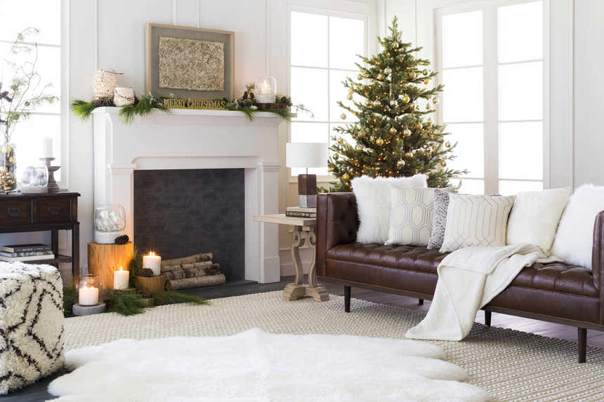 Cozy living room scene with a cream Christoval Area Rug, brown leather sofa, fireplace, and Christmas tree. Roomscene-Rectangle