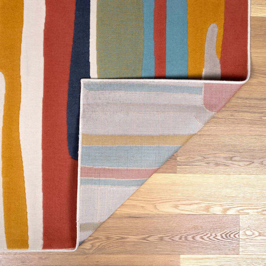 Close-up of the New Southfields Area Rug showing its abstract design, aqua, charcoal, and mustard colors, and woven backing. Fold