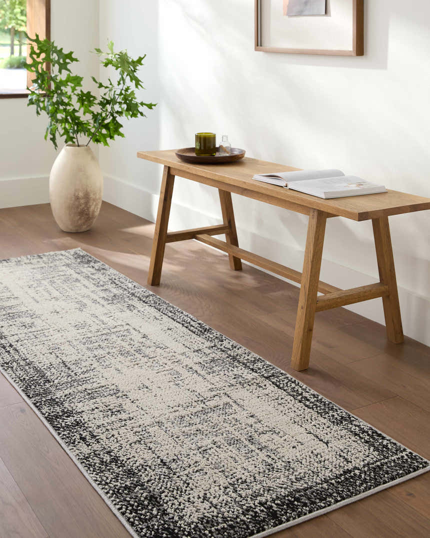 Hallway scene with a Colson Gray Area Rug, wood bench, vase with greenery, and hardwood floors. Roomscene-Runner