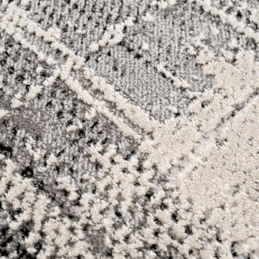 Close-up of the Colson Gray Area Rug showing its silver, onyx, and gray contemporary pattern and soft, textured pile. Texture