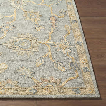 Close up of the hand-tufted Cedric Oushak Area Rug. Features ash, silver, and off white floral pattern on a wool rug. Front