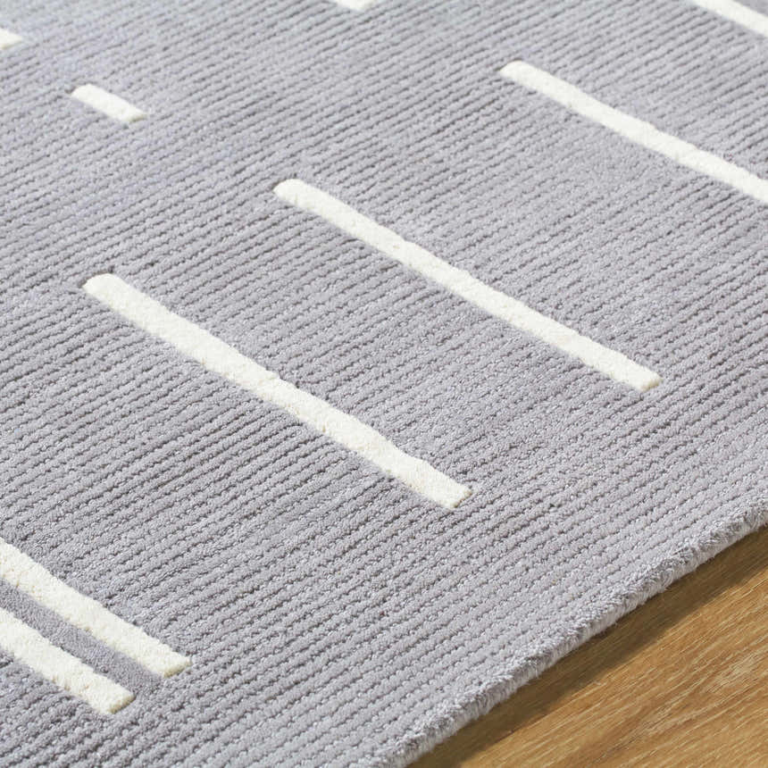 Close-up of the Charan Slate Gray Area Rug. Gray wool rug with a contemporary ivory stripe design and textured pile. Texture