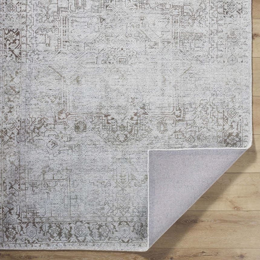 Close-up of the Clodia Area Rug. Hand-tufted polyester rug in charcoal, ivory, silver gray, and taupe with traditional pattern. Fold