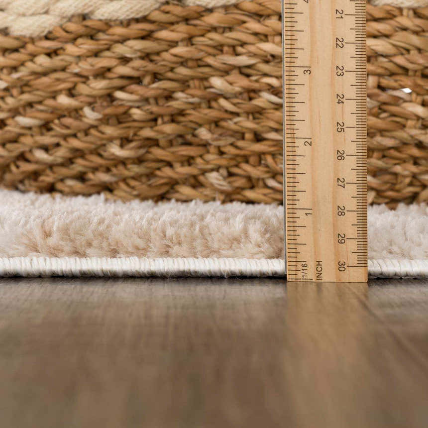 Close up of the pile height of the Canika Checkered Cream Washable Area Rug, next to a ruler. Pile