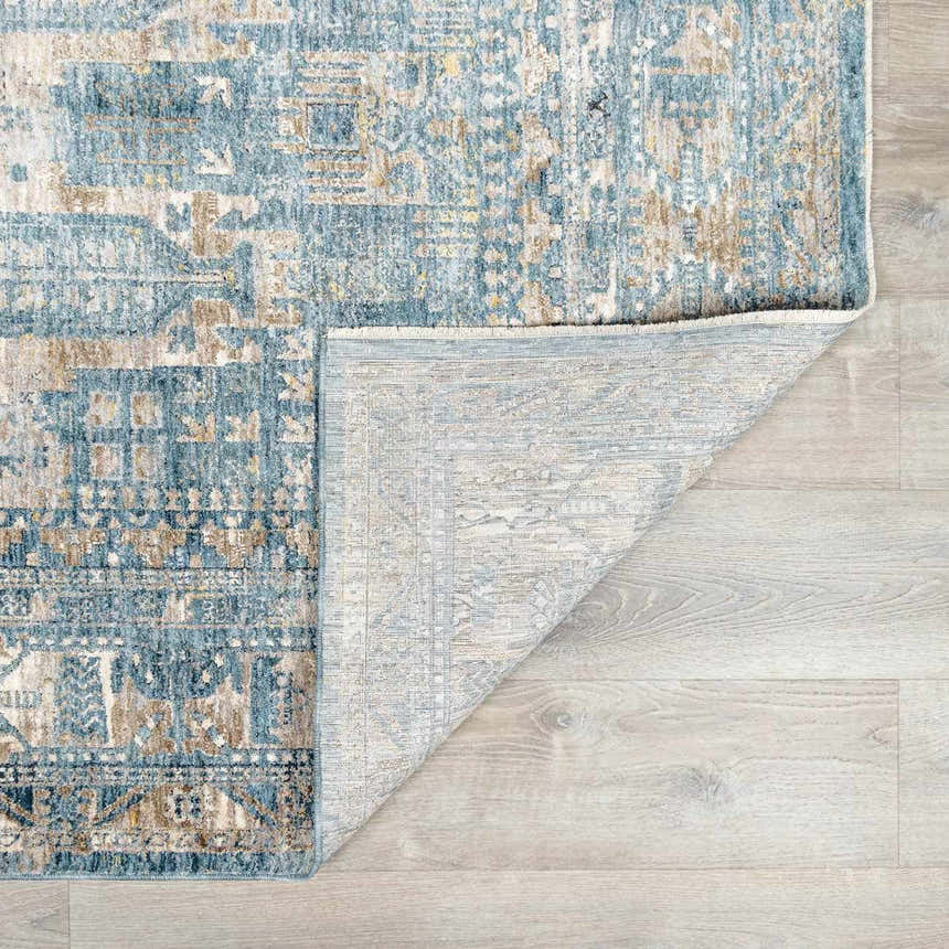 Close-up of the Mirabel Denim Blue Traditional Rug showing its blue, cream, and brown oriental pattern and woven texture. Fold