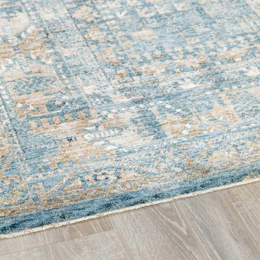 Close-up of the Mirabel Denim Blue Traditional Rug, showing its cream, tan, and blue oriental pattern and soft texture. Corner