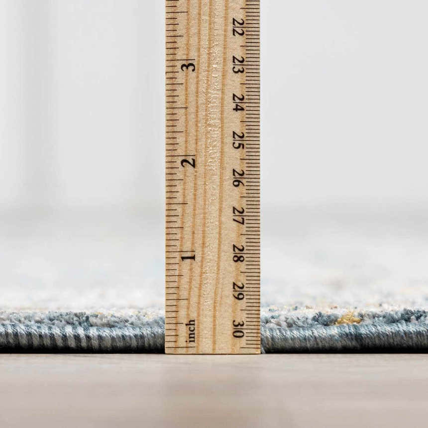 Close-up of the Mirabel Denim Blue Traditional Rug showing the pile height with a ruler. Pile