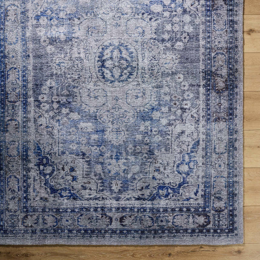 Close up of the hand tufted Csilla Area Rug. Traditional design in arctic sky, blue, and ivory. Corner