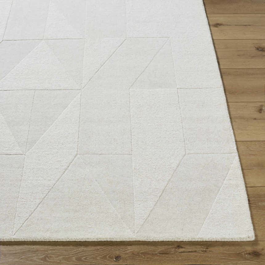 Close-up of the ivory Callie Area Rug showing its geometric pattern and hand-loomed wool texture on hardwood floor. Front