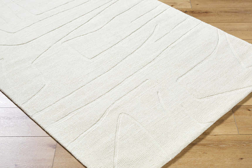 Close-up of the off-white Camryn Area Rug showing its hand-loomed texture and contemporary geometric design. Corner