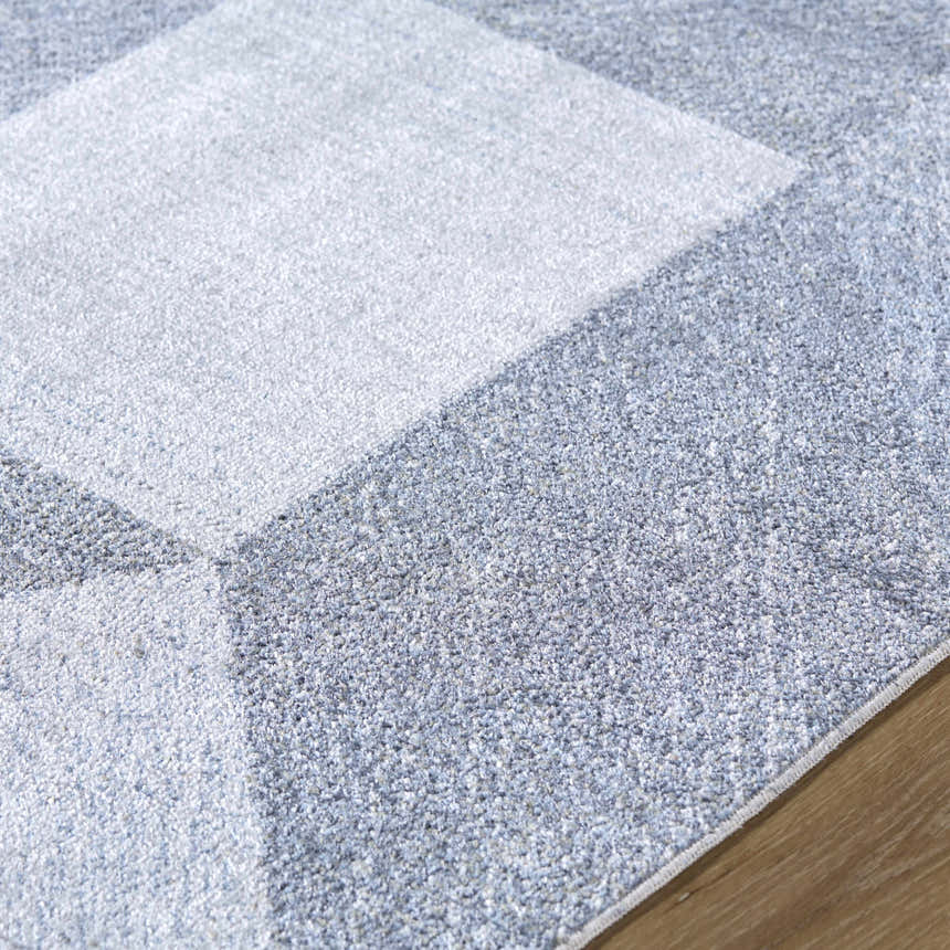 Close up of the Chachi Washable Geometric Rug, featuring a gray and light gray geometric pattern. Texture