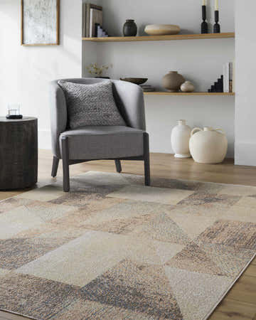 Living room scene with a gray chair and the Chachi Washable Geometric Area Rug in dark brown, red, light brown, and navy. Roomscene-Rectangle