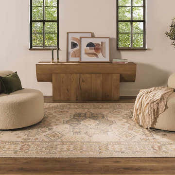 Living room scene with a Chaela Ivory & Olive Area Rug, wood console table, beige chairs, and natural light from two windows. Roomscene-Rectangle