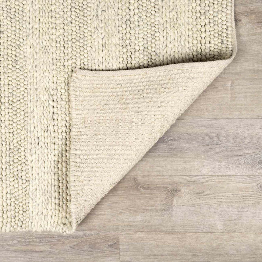 Close-up of the Clarke Textured Braided Stripe Rug in dark beige, showing the hand-woven texture and backing. Fold