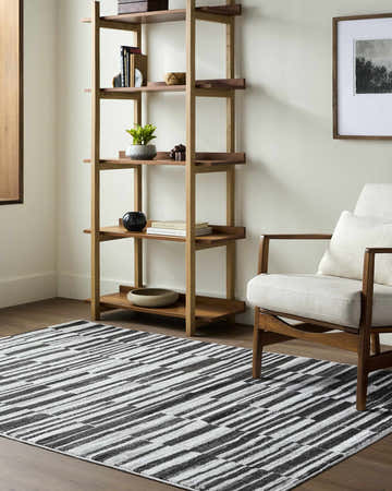 Living room scene with a Cemach Cream Area Rug, wood bookcase, and mid-century modern chair. Roomscene-Rectangle