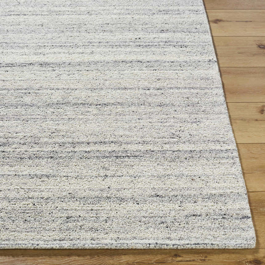 Close-up of the hand-tufted Capote Charcoal Area Rug. Wool rug with charcoal, ivory, and slate gray horizontal stripes. Front