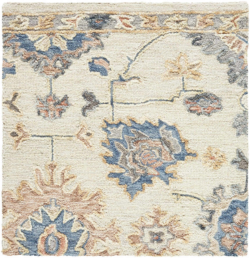 Close-up of Candid Oushak Area Rug. Hand-tufted wool rug with cream background and light brown and steel blue floral pattern. Swatch