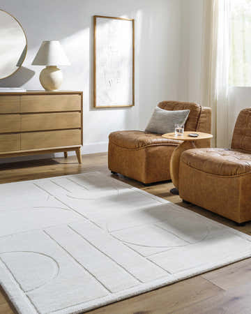 Living room scene with tan leather chairs and a geometric off white Carola Area Rug. Roomscene-Rectangle