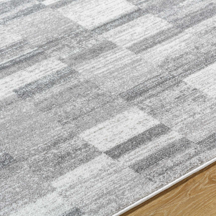 Close-up of the Cherie Medium Gray Area Rug showing its light silver and gray contemporary geometric pattern. Texture