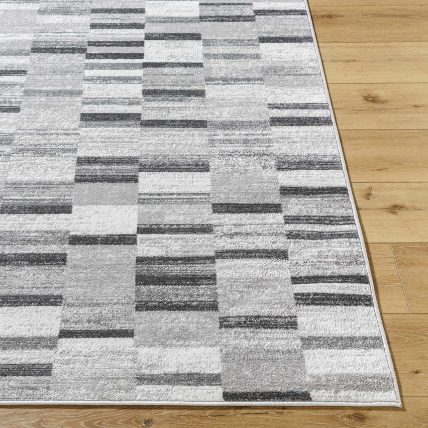 Close up of the Cherie Cream Area Rug showing its gray, light silver, and sage geometric pattern. Front
