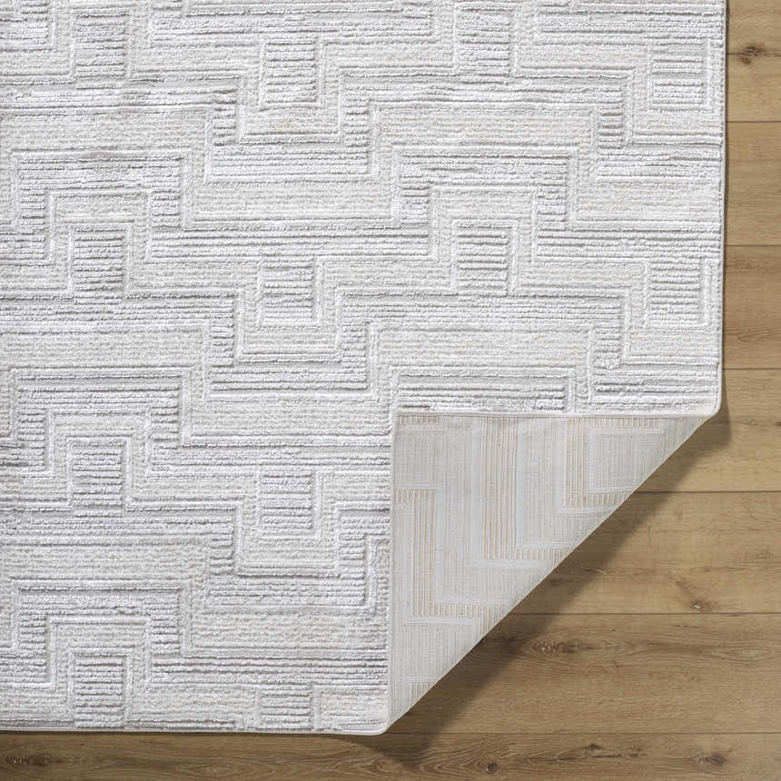 Close-up of the Cormac Area Rug. Cream and ivory tones with a geometric, contemporary pattern and machine-woven texture. Fold