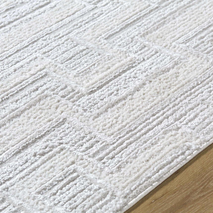 Close up of the Cormac Area Rug showing its cream, ivory, and light gray textured pattern. Texture