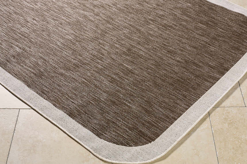 Close-up of the Chetan Dark Brown Area Rug showing its woven texture, cream border, and dark brown and cream colors. Corner
