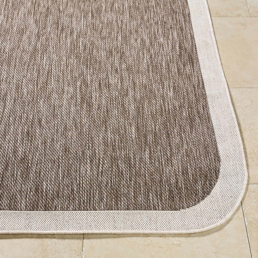 Close-up of Chetan Dark Brown Area Rug showing cream border and textured dark brown and cream weave. Front