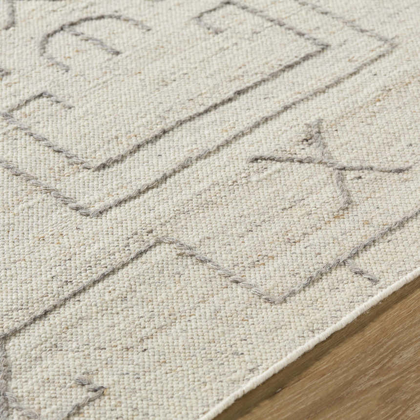 Close up of the beige wool Chanda Area Rug showing its hand woven texture and contemporary geometric pattern. Texture