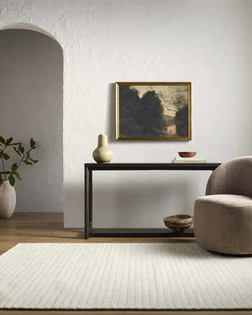 Living room scene with a cream Destry Ivory area rug, console table, artwork, and a taupe chair. Roomscene-Rectangle