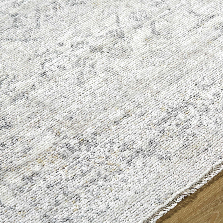 Close-up of the Alivia Area Rug, showing its ivory, charcoal, and gray traditional pattern and soft polyester texture. Texture