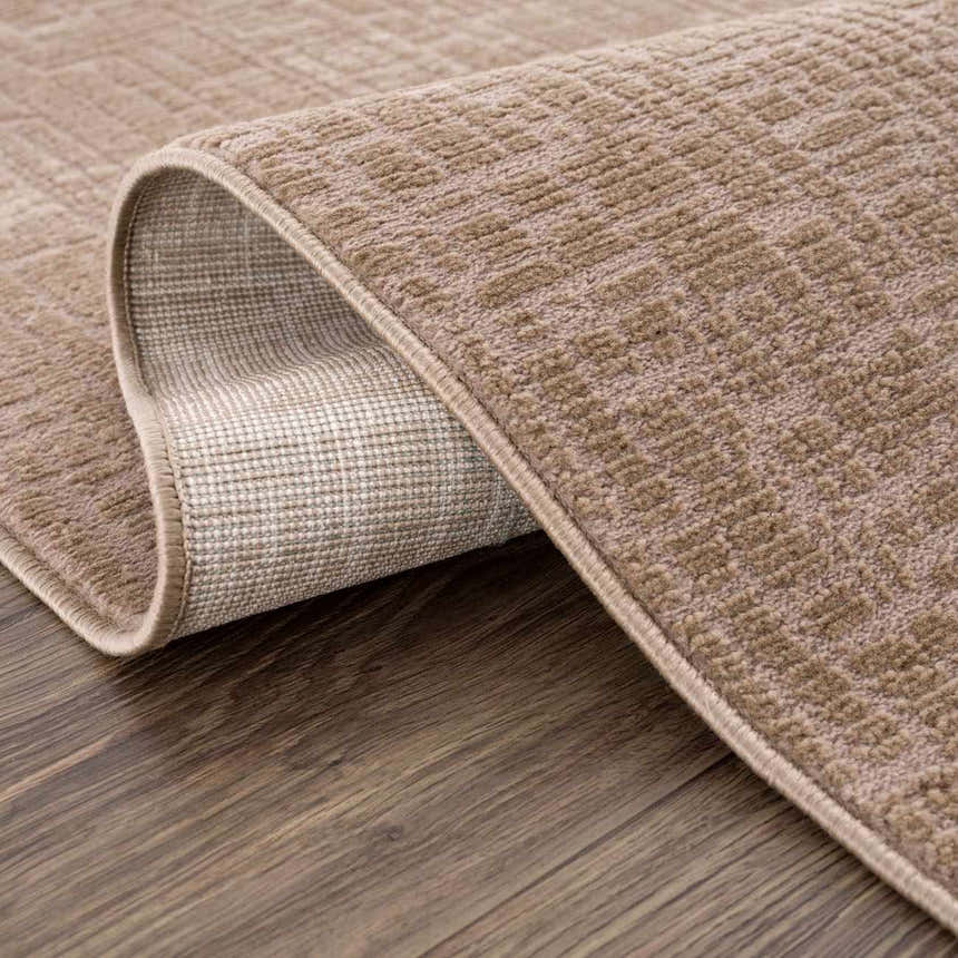 Close-up of the Leanna Light Brown Washable Area Rug showing its textured weave, light brown color, and durable backing. Fold