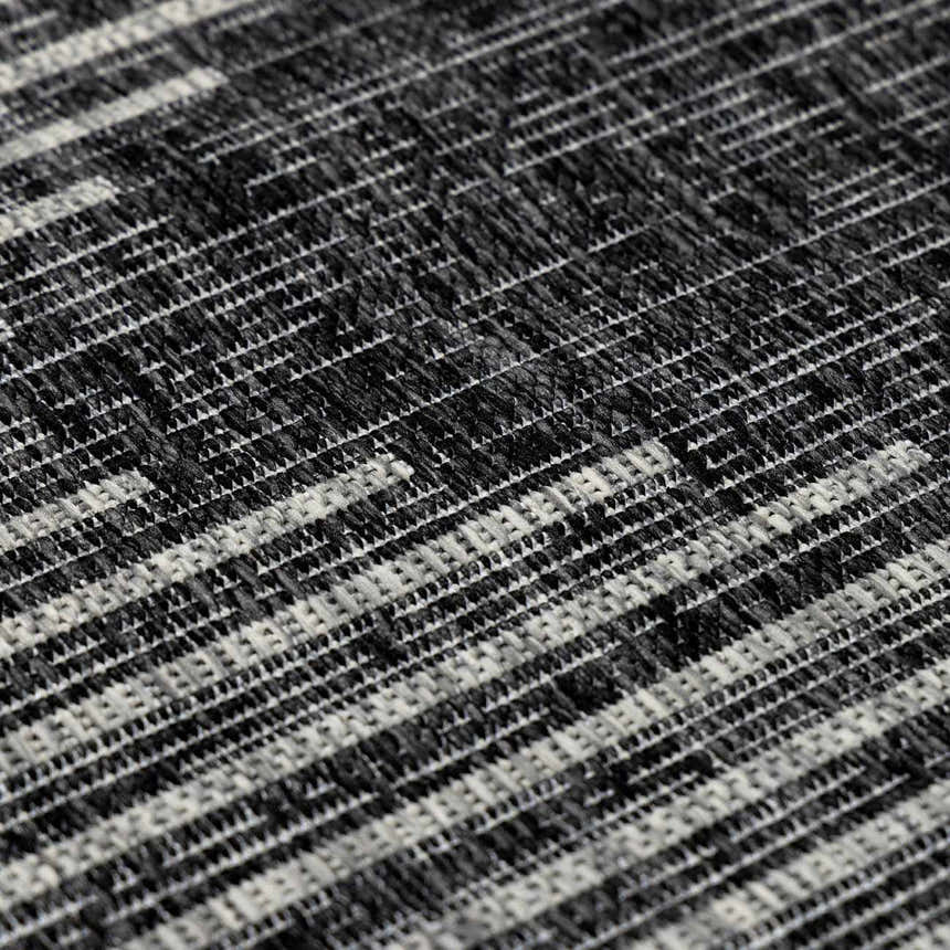 Close-up of the Stephan Area Rug showing a black, charcoal, and cream contemporary striped pattern and woven texture. Texture