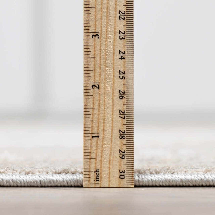 Close up of the Engin Thick Luxe Area Rug pile height with a ruler. Pile