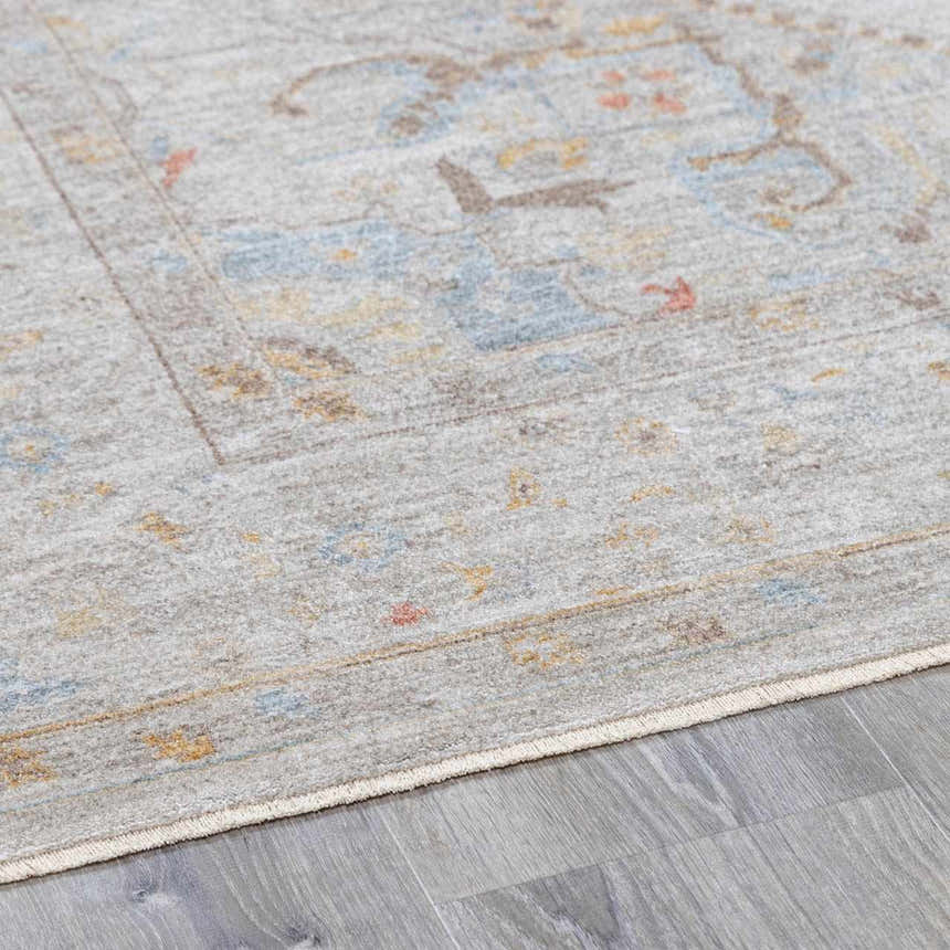 Close-up of the Engin Thick Luxe Area Rug with a traditional pattern in amber, blue, and gray tones. Pile