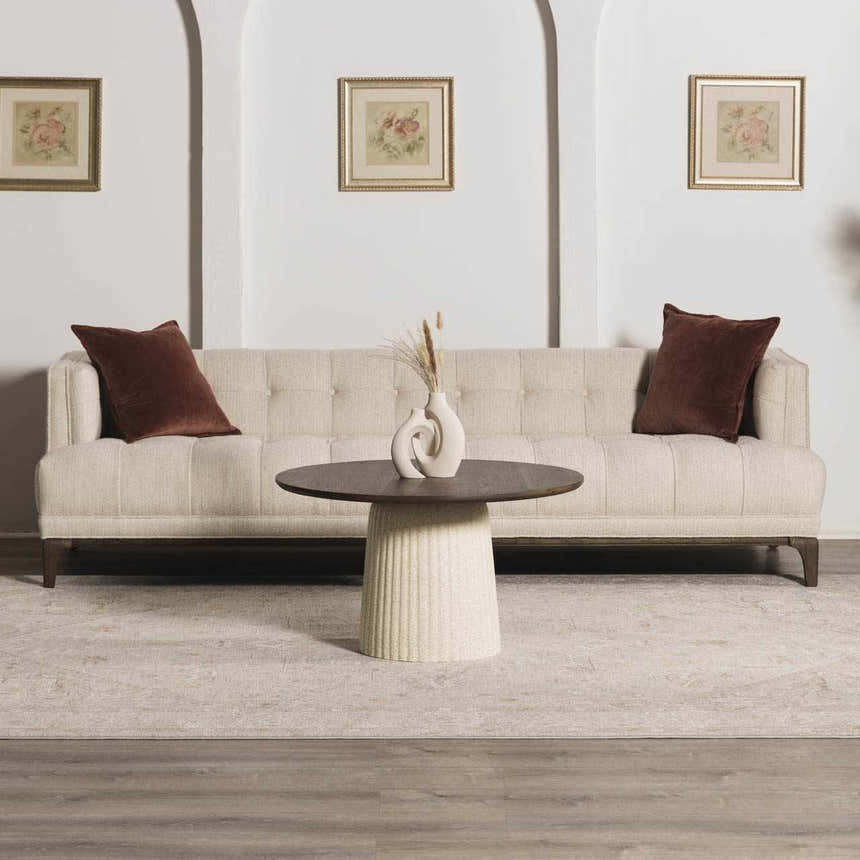 Living room scene with a neutral sofa, round coffee table, and Engin Thick Luxe Area Rug in amber and gray tones. Roomscene-Rectangle