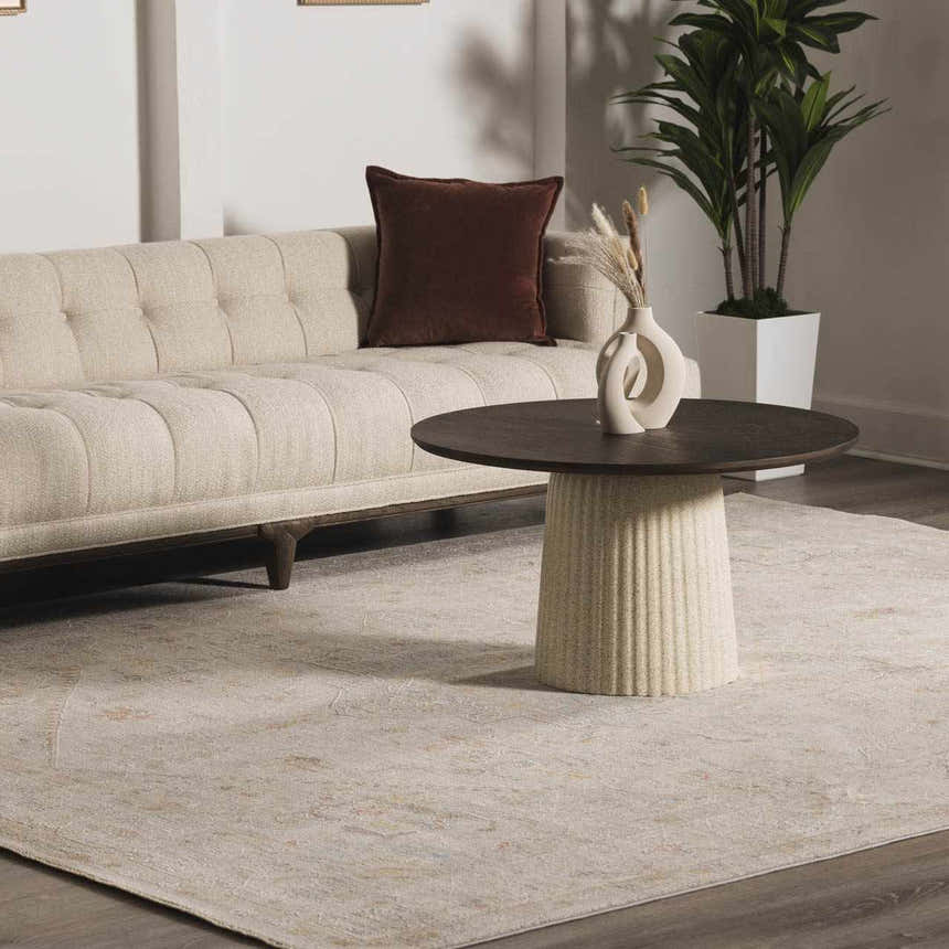 Living room scene with a neutral sofa, round coffee table and the Engin Thick Luxe Area Rug in amber and taupe. Roomscene-Rectangle