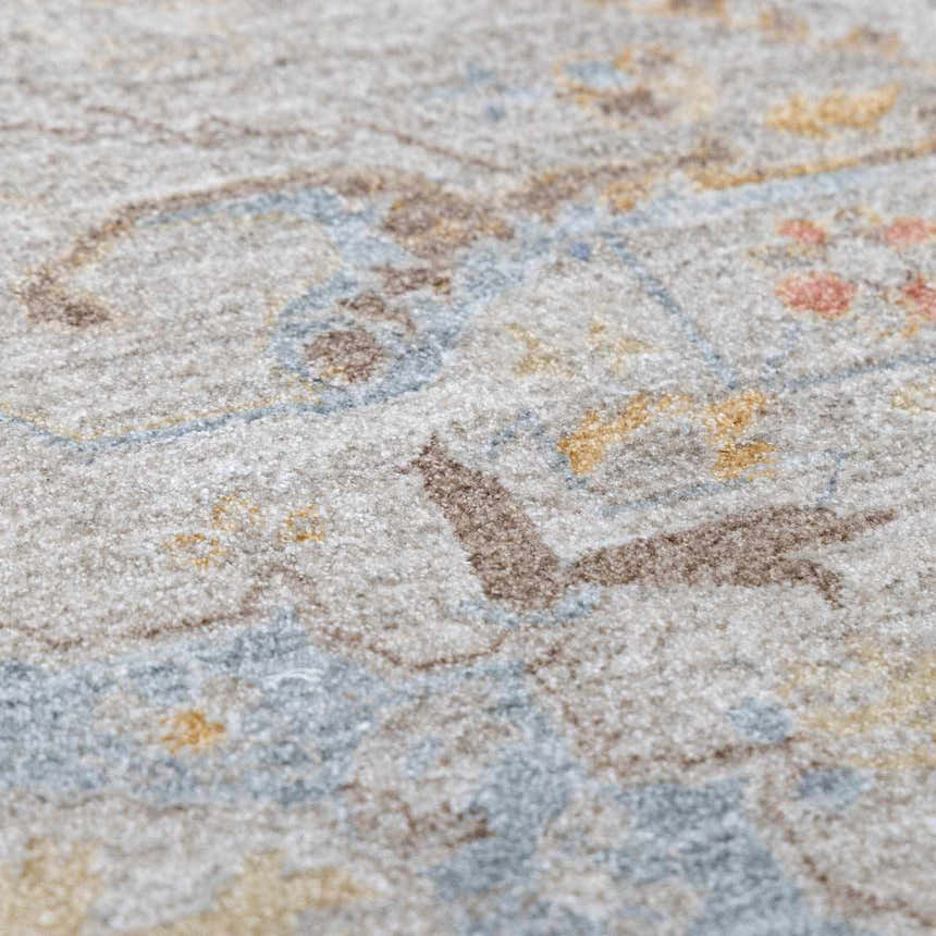 Close-up of the Engin Thick Luxe Area Rug showing its amber, brown, pink, and gray traditional pattern and soft texture. Texture