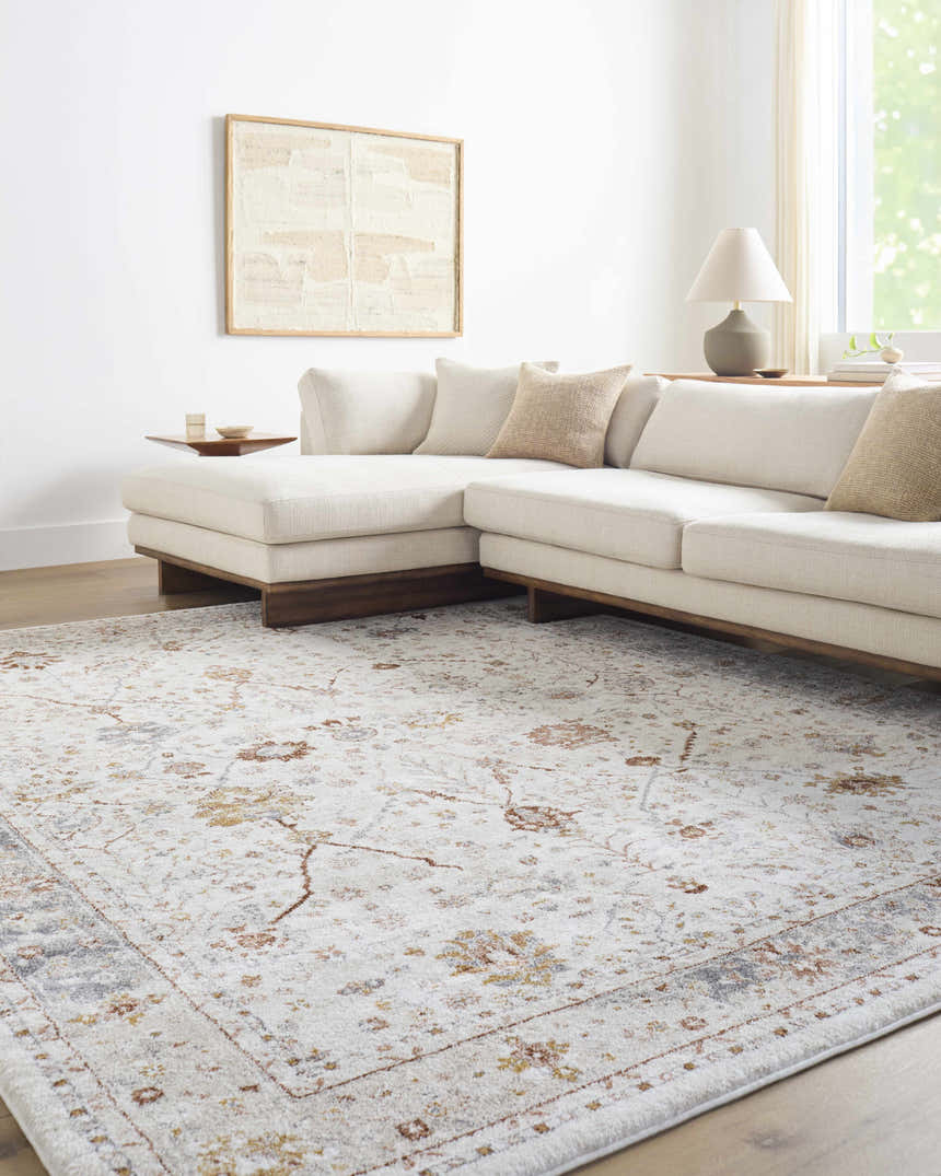 Living room with a Paatan Luxe Floral Oushaq Area Rug, cream sectional sofa, wood floors, and neutral decor. Roomscene-Rectangle