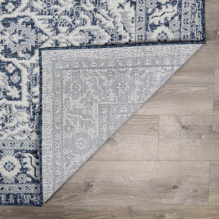 Close-up of the Etoile Navy Blue Performance Rug showing its traditional pattern and durable backing. Fold