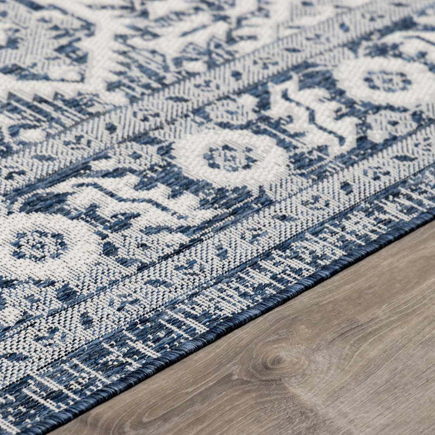 Close-up of the Etoile Navy Blue Performance Rug showing its traditional floral pattern and woven texture. Corner