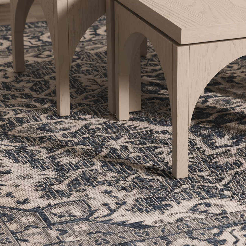 Close-up of the Etoile Navy Blue Performance Rug with a detailed traditional pattern and light wood furniture legs. Roomscene-Rectangle