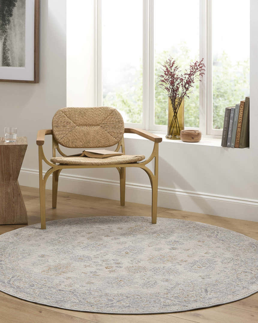 Sunlit reading nook with round Coby Sage Avant Garde rug, woven chair, wood accents, and soft, neutral hues. Roomscene-Round