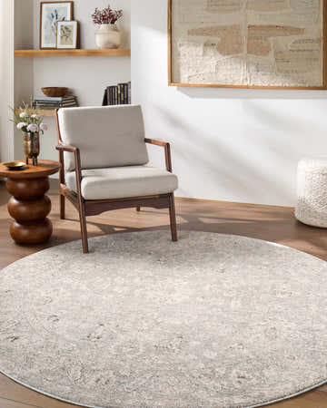 Living room scene with round Azania Area Rug in cream and light sage, styled with chair, side table, and neutral decor. Roomscene-Round