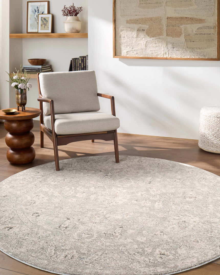 Living room scene with round Azania Area Rug in cream and light sage, styled with chair, side table, and neutral decor. Roomscene-Round