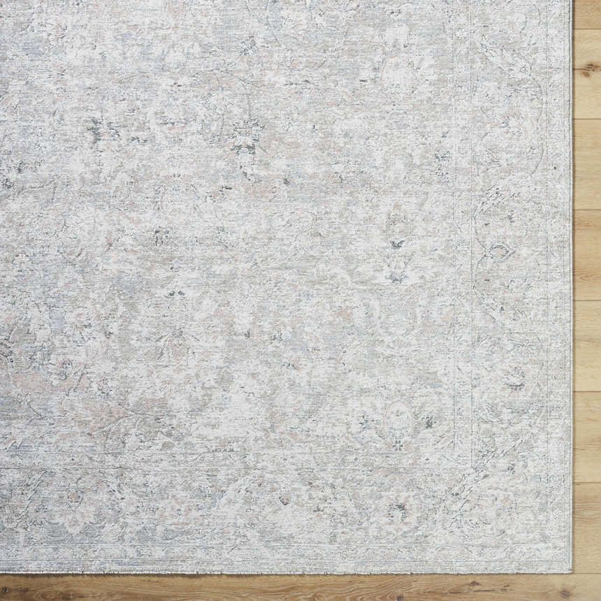 Close-up of the Azania Area Rug. Cream, light sage, and slate blue traditional pattern on a soft polyester rug. Corner