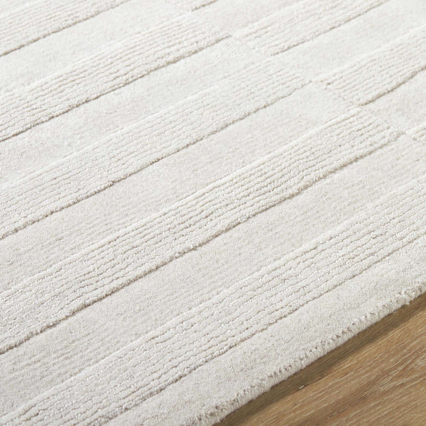 Close-up of the light silver Aretha Area Rug, a hand-loomed wool rug with a subtle striped pattern and textured feel. Texture
