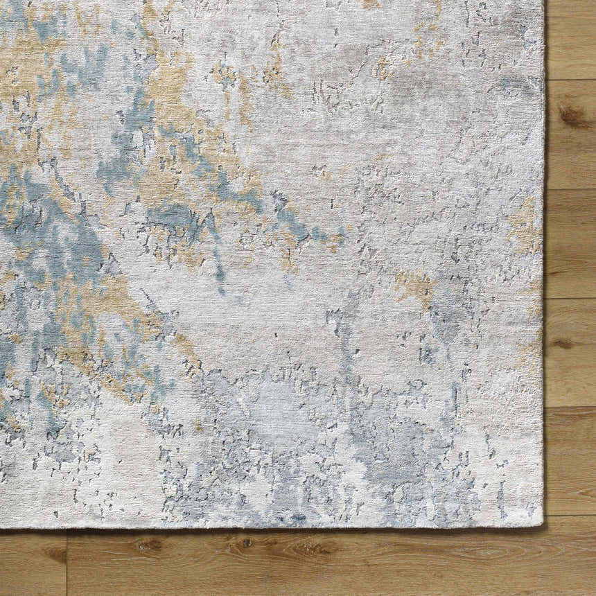 Close-up of the hand-knotted Follansbee Area Rug. Beige, charcoal, gray, and light sage abstract design. Viscose texture. Corner